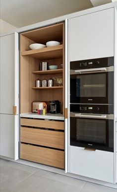 an open cabinet with two ovens in it