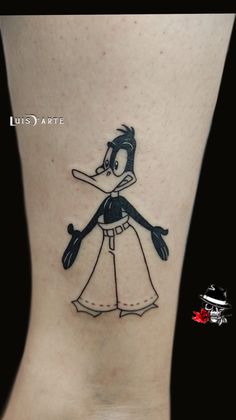 a cartoon character tattoo on the side of a woman's leg, with a black and white dress