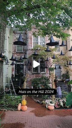 a brick building with lots of halloween decorations on it's front lawn and trees