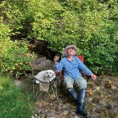 a man sitting in a chair next to a dog