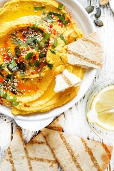 hummus and pita chips on a white plate