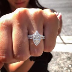 a woman is showing off her engagement ring