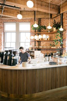 a man standing behind a counter in a coffee shop