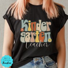 "Welcome your students to Kindergarten with this super cute Kinder teacher shirt. This Kinder Retro tshirt is the perfect Teacher Team Tee. This is such a comfy Tee with a loose fit, perfect to go with your favorite leggings. SHIRT DETAILS We use Bella+ Canvas t-shirts. UNISEX sizing they are meant to have a loose fit. Please refer to our sizing chart in the photos for measurements along with tips on the fit for both ladies and guys. *If you are looking for a different fit, tank top, sweatshirt Early Childhood Education Shirts, Teacher Shirts Kindergarten, Brown Pre K Shirts For Teaxhers, Early Childhood Education T Shirts, Third Grade Teacher Shirts, Retro Crew Neck T-shirt For Teacher Appreciation, Kindergarten Teacher Shirts, Teacher Tees, Crew Shirt