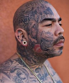 a man with tattoos and piercings on his head