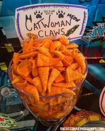 a bowl filled with cheetos sitting on top of a table next to a sign