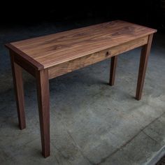 a wooden table sitting on top of a cement floor