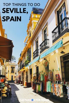 an alley way with clothes on display and the words top things to do in seville, spain