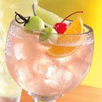 a glass filled with ice and fruit on top of a table