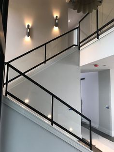 an open stairwell leading up to a second floor with lights on the wall and ceiling