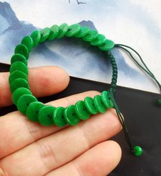 "Hand Weave Rope Bracelet,donut \"PingAn\" coin circle green jade stone beaded bracelet,amulet,protector,good mood,good lucky gift material: green jade stone ,rope  Size:  10mmx2mm Color: green rope length:6\"-8\"  style: weave rope,adjustable bracelet Price: one bracelet ❤ If you want other length Bracelet, Please connect me free. ❤Please read the store policy before purchase. ❤ Thank you for visiting my shop!" Cheap Green Braided Bracelets For Festivals, Jade Bead Necklace, Lucky Gifts, Jade Stone, Jade Beads, Green Jade, Adjustable Bracelet, Good Mood, Stone Beads