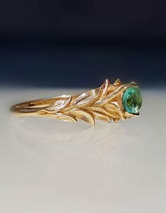 ★★This unique nature inspired ring is set with a natural 0.25 carats round Emerald.  The ring is designed as a branch of leaves made of 14k/18k solid yellow gold  The Emerald color is bright vivid teal-green , high quality of natural Emerald. The ring is very dainty but yet impressive for engagement, wedding, or anniversary. A ring to enjoy forever! ★★ ITEM DETAILS: Metal: 14/18K  solid white/yellow/rose gold by your choice. Ring Size: Size Selectable (4-8 US sizes) width: The band is 7 mm wide Leaves Engagement Ring, Engagement Ring Leaf, Nature Wedding Ring, Amethyst Wedding, Leaf Engagement Ring, Nature Inspired Rings, Emerald Gem, Gold Gemstone Ring, Unique Nature