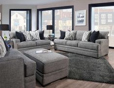 a living room filled with furniture and lots of window sill space in front of large windows