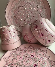 pink and white dinnerware with beaded designs on the plates, cups and saucers