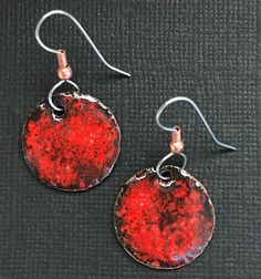 Red and Black Handmade Dangle Enameled Earrings. These beautiful Red and Black Earrings would add an Extra splash to many outfits. All of my jewelry is made with my Love. These items are powdered enamel over Copper, torch fired by hand, with many layers and firings. The backs are finished with enamel. The ear wires are Stainless steel and Hypoallergenic and come with rubber backs to help prevent loss. I have been making jewelry since 2010 and find great pleasure in seeing my pieces being worn. I Red Round Jewelry With Black Enamel, Red Round Enamel Earrings, Red Enamel Round Earrings, Nickel-free Red Copper Earrings, Red Copper Earrings Gift, Red Copper Earrings As Gift, Orange Copper, Red Earrings, Enamel Earrings