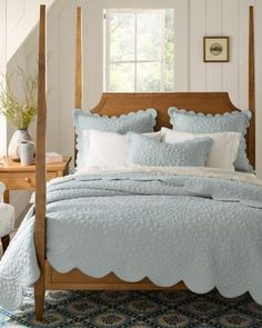 a bed with blue comforters and pillows in a room