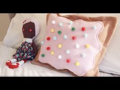 a stuffed animal sitting on top of a bed next to a pillow with sprinkles