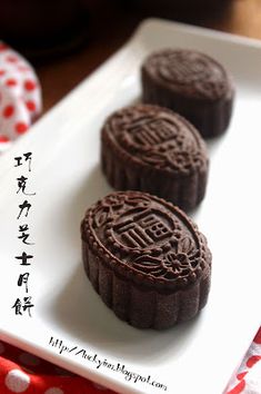 three cookies on a white plate with chinese writing