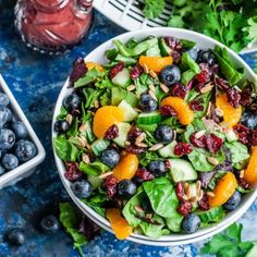 a salad with oranges, blueberries and spinach