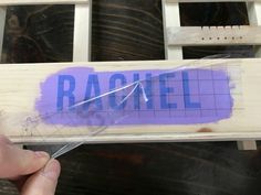 a person holding a piece of wood with the word racquet taped to it