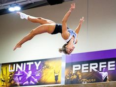 a woman is doing tricks on the balance beam