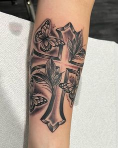 a cross tattoo with butterflies on it