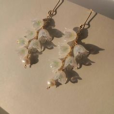 "*Free shipping on orders more than $35 in U.S. Territories ⭐Stunning delicate lily of the valley drop earrings Perfect gift idea for garden lovers or a treat for yourself Light weight and comfortable to wear everyday. They are very cute and romantic, will easily blend with your style. 📌DETAILS *Quantity: 1 pair *Measurements:    6 flowers:Length 6.7cm (2.63\"), Drop 4.2cm (1.65\"), Width 2 cm (0.78\") *Materials: bronze with gold plated(nickel free)/   acrylic/ natural freshwater pearl 📌NOTES Due to the variations in pearls, no two earrings will ever be the same so you'll always have a unique look. Colors may vary slightly due to different computer monitor settings. Substances like oil, nail polish, nail polish remover, chlorine, and perfume may react with metal/plated jewelry and cause Flower Shaped Chandelier Earrings For Gift, Whimsical Dangle Jewelry For Wedding, Delicate Handmade Chandelier Earrings For Gift, Whimsical White Dangle Jewelry, Delicate Handmade Chandelier Earrings Gift, Delicate Handmade Drop Bridal Earrings, Dainty White Chandelier Earrings For Gift, Delicate Dangle Chandelier Earrings, Delicate Earrings With Flower Charm