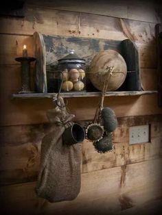 an old wooden shelf with pots and pans hanging from it's hooks on the wall