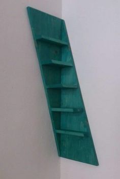 a green shelf mounted to the side of a white wall