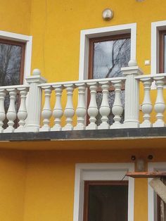 a yellow building with white balconies and windows