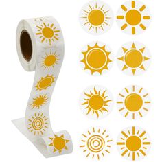 a roll of white and yellow stickers with sun designs on them next to a roll of toilet paper