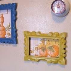 three framed pictures hang on the wall next to a clock