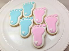 decorated cookies with pink and blue feet on a plate