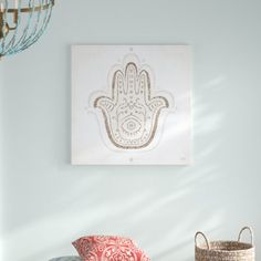 a hamsa hanging on the wall in a room with two baskets and a lamp