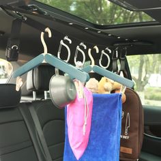 the back seat of a car with luggage hanging from it's hooks and two mugs