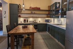 a kitchen with green cabinets and wooden counter tops