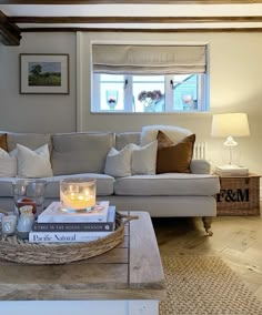 a living room with a couch, coffee table and two candles on top of books