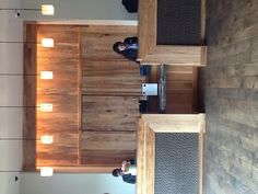 two people sitting at the front desk of a wooden building with wood paneling on the walls