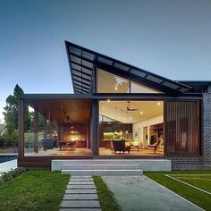 a modern house with grass and stairs leading up to it