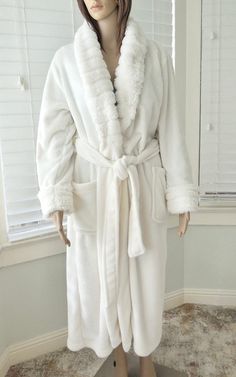 "This is a Gorgeous House Robe. It is a plush white robe with a fluffy white shawl collar and sleeve trim. This lightweight robe has two front patch pockets and a wrap around sash belt with an inside waist tie. It shows no signs of wear and is in Excellent Condition!   100% Plush Fleece Polyester. Label:      CAROLE HOCHMAN Made in China Size:         Small to Medium (Double Check Measurements) Measurements are taken with the garment LAYING FLAT. DOUBLE where applicable. Shoulder to Shoulder:  18\"  Armpit to Armpit:          20\"  Sleeve Length:           21\" Waist:                              21\" Length from Back Collar:  47\" Model Measurements: 33 24 34  5' 7\" This garment has been washed and ready to wear. Visit my shop for your wardrobe and accessories. www.etsy.com/shop/seadawlv Cozy White Winter Robe, Fluffy Shawl, Fitted White V-neck Robe, White Bath Robe, White V-neck Loungewear Robe, Bath Robe White, Plush Robe, White Shawl, Sash Belts