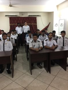 a group of men in uniform sitting at desks