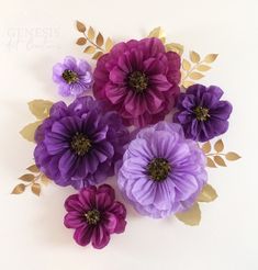 purple flowers with gold leaves are arranged on a white surface, and the petals have been cut out to make them look like they's coming out of paper