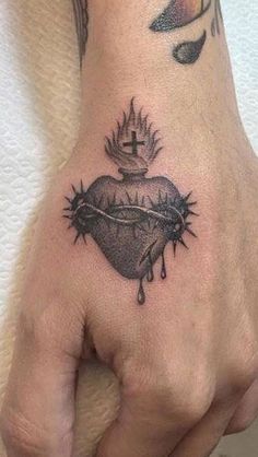 a hand with a heart and crown tattoo on it