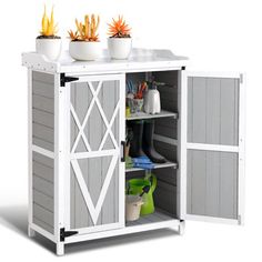 an outdoor storage cabinet with two pots and plants on top, in front of a white background