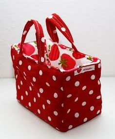 a red and white polka dot bag with strawberries on the inside is for sale