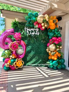 an entrance to a house decorated with balloons and streamers that spell out happy nights