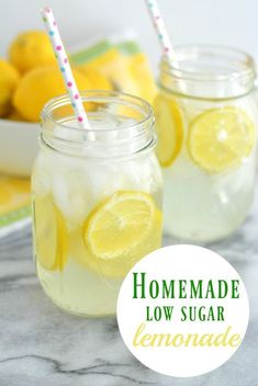 two mason jars filled with lemonade sitting on top of a marble counter next to some lemons