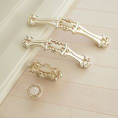 three gold handles and knobs on a white door