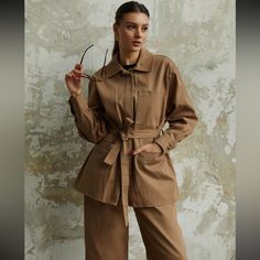 Gabardine Belted Tan Shirt Jacket Beige Long Sleeve Outerwear With Belted Cuffs, Belted Long Sleeve Outerwear For Daywear, Spring Long Sleeve Outerwear With Belted Cuffs, Spring Brown Utility Jacket For Workwear, Utility Long Sleeve Outerwear With Buckled Cuffs, Fall Outerwear With Belted Cuffs For Daywear, Khaki Long Sleeve Outerwear, Brown Outerwear With Pockets For Daywear, Brown Spring Outerwear With Belted Cuffs