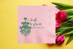 a pink napkin with the words first of may printed on it next to tulips